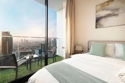 a bedroom with a bed and a view of a city at Brand New Apt On Top Floor 1BR w Spa And Pool in Dubai