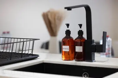 two bottles of sauce sitting next to a kitchen sink at Brand New Apt On Top Floor 1BR w Spa And Pool in Dubai