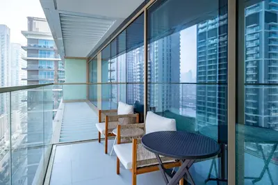 a balcony with chairs and a table on a building at Homes Beyond I Seaside 1BR Retreat with Beach Access in Dubai