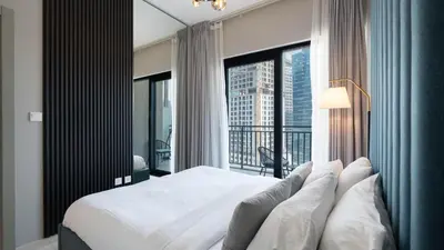 a bedroom with a bed and a large window at Keyrock Living - Lakeview Retreat in Business Bay in Dubai