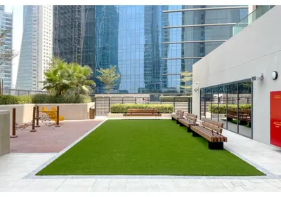 a park with benches and grass in a city at Keyrock Living - Lakeview Retreat in Business Bay in Dubai