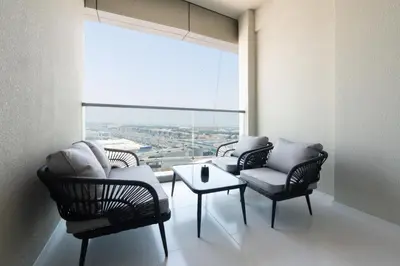 a living room with chairs and a table and a large window at Keyrock Living - Exclusive Luxury at Aykon Tower in Dubai