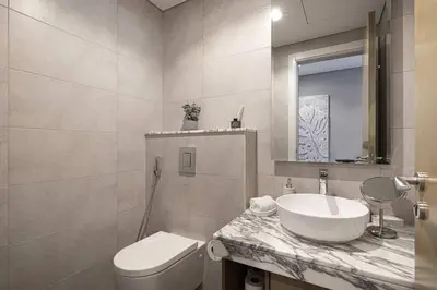 a white bathroom with a sink and a toilet at Modern 3-Bedroom Apartment with Breathtaking City Views in Dubai