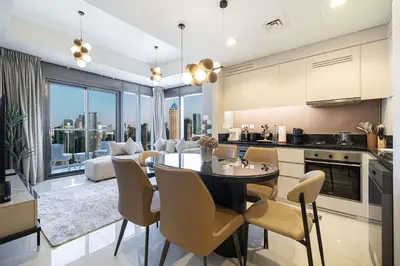 a kitchen and living room with a table and chairs at Modern 3-Bedroom Apartment with Breathtaking City Views in Dubai
