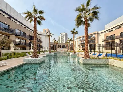 a swimming pool with palm trees and buildings at Serene 2BRplus1 Haven in Oakley JVC - 5star Amenities in Dubai