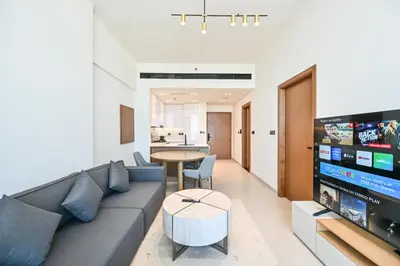 a living room with a couch and a tv at Pure Voyage JVC in Dubai