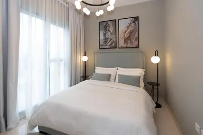 a bedroom with a white bed and a window at Keyrock Living - Elegant City Escape at Zada Tower in Dubai