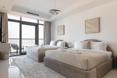 a bedroom with two beds and a couch at UrbanStays Dubai - Paramount Midtown in Dubai