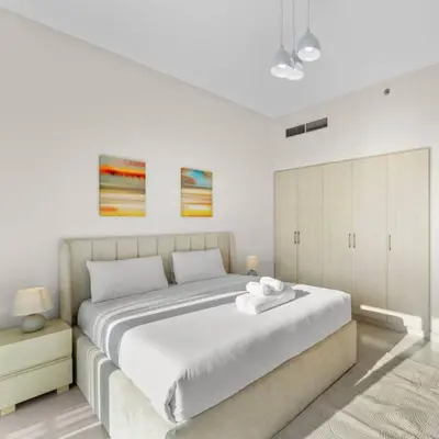 a bedroom with a large bed with white sheets at 016 - Dubai Hills in Dubai