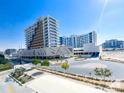 an empty parking lot in front of a tall building at Studio Charm at Legacy Ideal Arjan Stay in Dubai