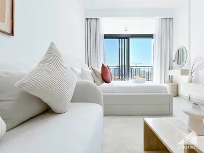 a white living room with a white couch and a window at Luxurious Studio in Arjan With Balcony & Views in Dubai