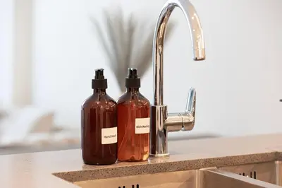 two bottles of soap sitting next to a sink at NEW 2BR in Arjan with Private Pool in Dubai