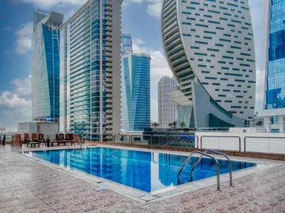 a swimming pool in a city with tall buildings at Luxury Studio Apartment in JVC near Circle Mall in Dubai