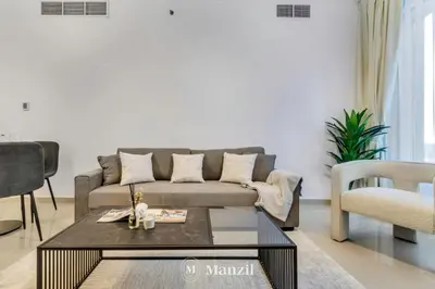 a living room with a couch and a table at Luxury Studio Apartment in JVC near Circle Mall in Dubai