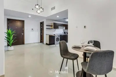 a dining room and kitchen with a table and chairs at Luxury Studio Apartment in JVC near Circle Mall in Dubai