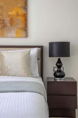 a bedroom with a bed and a lamp on a nightstand at Frank Porter - Damac Ghalia in Dubai