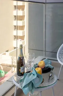 a glass table with a bottle and a plate of fruit at Frank Porter - Golden Dream Tower in Dubai