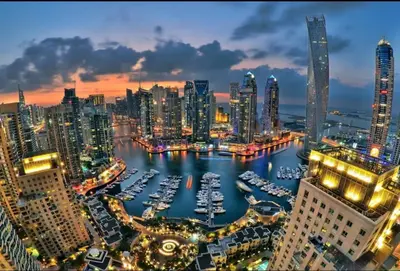 a city skyline at night with boats in the water at Dubai Marina Escan Tower Family Apartment in Dubai
