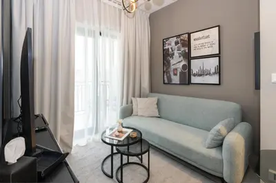 a living room with a couch and a tv at Keyrock Living - Lakeview Luxury with Pool Access in Dubai