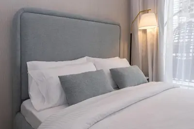 a bedroom with a white bed with two pillows at Keyrock Living - Lakeview Luxury with Pool Access in Dubai