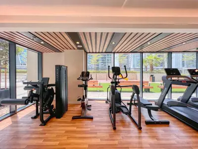 a gym with treadmills and cardio equipment in a building at Keyrock Living - Lakeview Luxury with Pool Access in Dubai