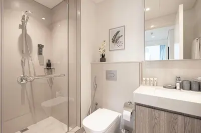 a bathroom with a shower and a toilet and a sink at Beautiful 2BR - Burj Views And Dubai Mall Connection in Dubai
