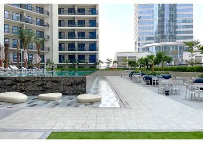 a patio with tables and chairs and a building at Keyrock - Zada Tower, Business Bay Lake-View Apartment in Dubai