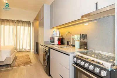 a kitchen with a sink and a stove top oven at Blue Breeze - Stylish Studio Retreat in MBR City in Dubai