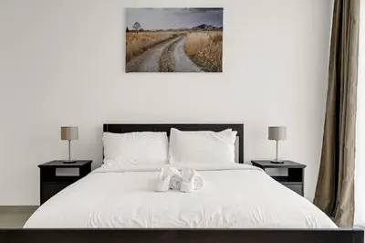 a bedroom with a white bed with shoes on it at CanalFront - Central Location up to 7 Guests in Dubai