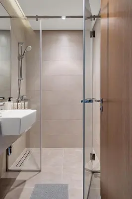 a bathroom with a sink and a glass shower door at CanalFront - Central Location up to 7 Guests in Dubai