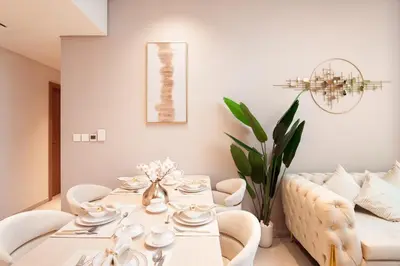 a dining room with a white table and a couch at Elite Royal Apartment - Panoramic Burj Khalifa View - Sky Edition - Luxurious - Zacharyas in Dubai