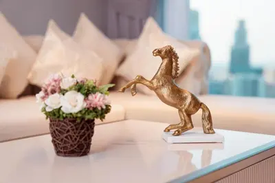 a statue of a horse on a table next to a couch at Elite Royal Apartment - Panoramic Burj Khalifa View - Sky Edition - Luxurious - Zacharyas in Dubai