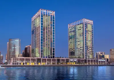 two tall buildings in a city next to a body of water at Keyrock Damac Maison Privée - Studio in Business Bay with Pool, Gym & Free Parking in Dubai