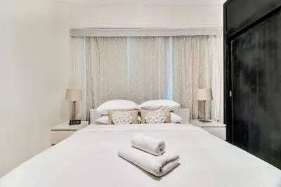 a bedroom with a large white bed with towels on it at GuestReady - Contemporary haven in Dubai Marina in Dubai
