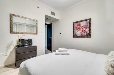a bedroom with a bed and a dresser and a mirror at GuestReady - Contemporary haven in Dubai Marina in Dubai