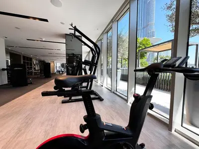 a gym with two exercise bikes in a room with windows at Stunning 1BR Burj View from Infinity Pool in Dubai
