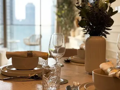 a wooden table with a vase and a table with glasses at Stunning 1BR Burj View from Infinity Pool in Dubai