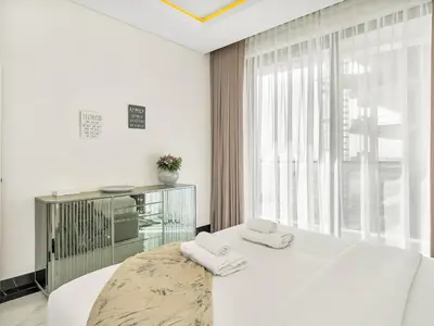 a white bedroom with a large bed and a window at Huge Lux 1BHK in Prime Business Bay with Private Jacuzzi in Dubai