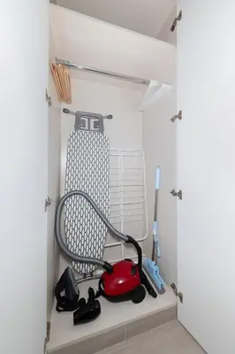 a cabinet with a vacuum cleaner and other tools in it at Luma Studio in Jumeirah Village Circle in Dubai