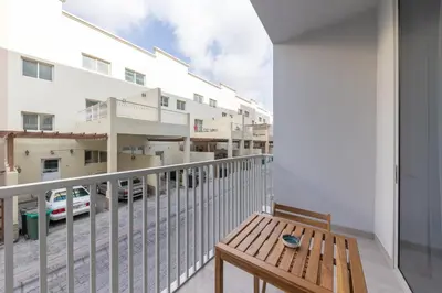 a balcony with a wooden bench and a view of a street at Luma Studio in Jumeirah Village Circle in Dubai