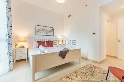 a bedroom with a bed and a table with a lamp at Balcony Overlooking the Swimming Pool, Just Minutes from the Park, Town Square Safi 1A, Al Yelayiss 2 by Deluxe Holiday Homes in Dubai