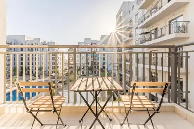 a balcony with two chairs and a table at Balcony Overlooking the Swimming Pool, Just Minutes from the Park, Town Square Safi 1A, Al Yelayiss 2 by Deluxe Holiday Homes in Dubai