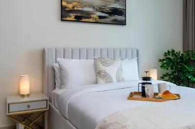 a bedroom with a bed with two night stands and two candles at Classy Upgraded High Floor Prime Location in Dubai