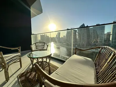 a balcony with chairs and a table and a view of a city at Bright Studio Burj Khalifa & Canal Views Pool in Dubai
