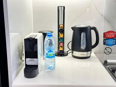 a kitchen counter with a coffee maker and a bottle of water at Bright Studio Burj Khalifa & Canal Views Pool in Dubai
