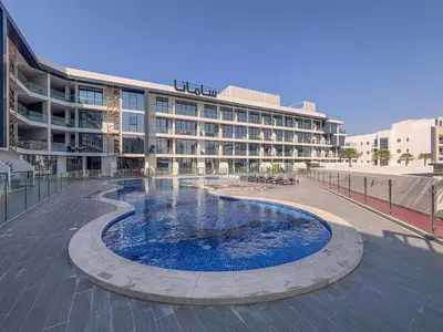 a large building with a large pool in front of it at Frank Porter - Samana Golf Avenue in Dubai