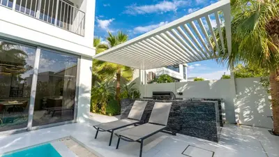 a patio with a chair and a swimming pool at Lavish Sidra 3 Villa, 4BR plus M,Private Pool BBQ in Dubai