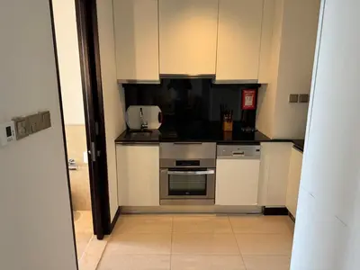 a kitchen with white cabinets and a stove top oven at Stylish studio Located in JW Mariott Hotel Dubai Marina in Dubai