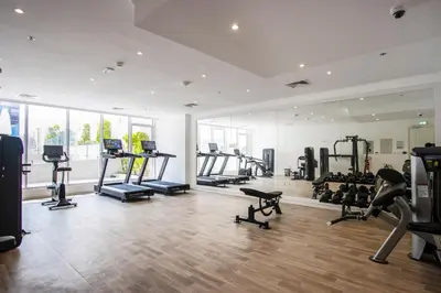 a gym with treadmills and machines in a room at Livbnb-Stylish 1B with Spacious Balcony in JVC in Dubai