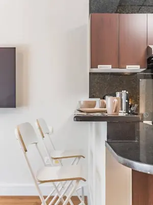 a kitchen with a counter with two chairs and a table at Special Rate - Luxurious Studio - Golf View in Dubai